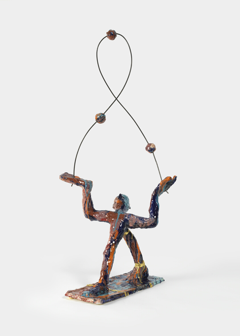 man standing juggling three balls by first light of day